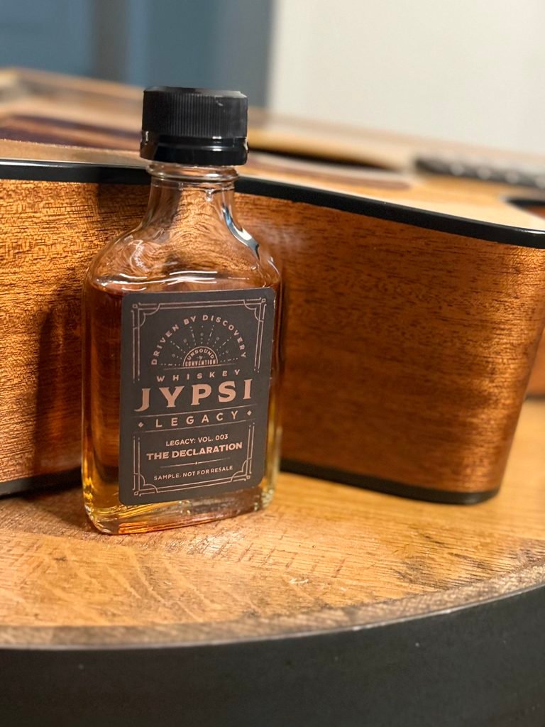 Whiskey JYPSI Legacy Batch 003 "The Declaration" nestled into crook of guitar